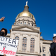 Demonstrators stand outside of the Capitol building in opposition to House Bill 531 on March 8, 2021 in Atlanta, Georgia. HB531 will restrict early voting hours, remove drop boxes, and require the use of a government ID when voting by mail.